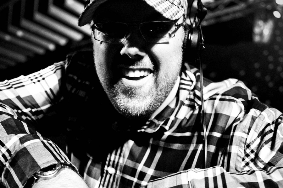 DJ Mads Laumann smiler overrasket mens han står bag mixer pulten