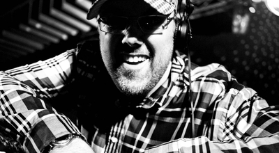 DJ Mads Laumann smiler overrasket mens han står bag mixer pulten