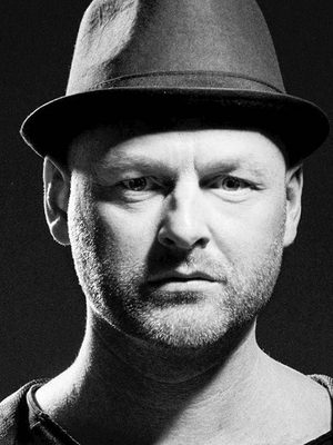 DJ Morten Hampenberg i mørke omgivelser iført en hat